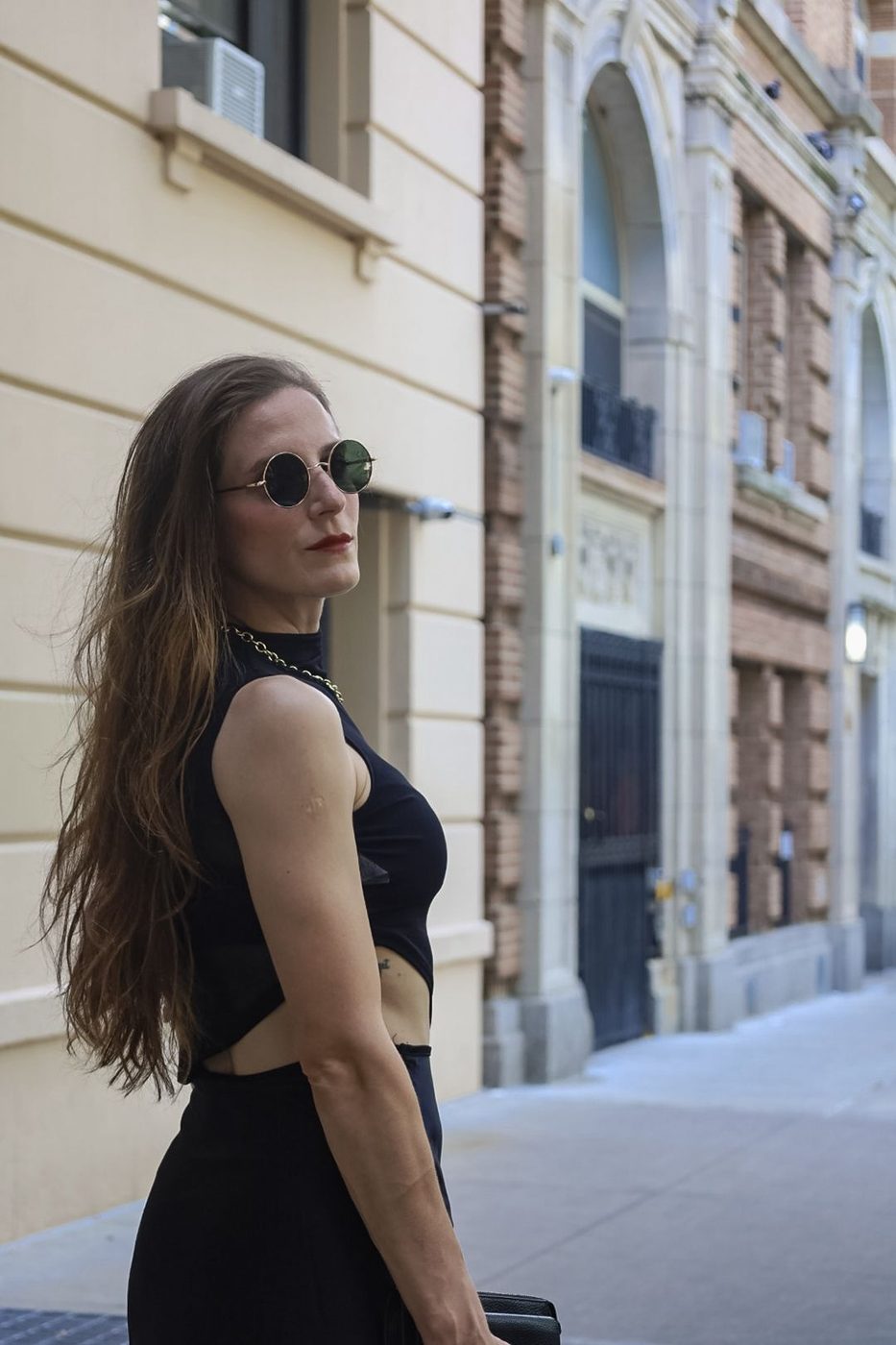 Gabriela in a black mock-neck top and round sunglasses on an Upper East Side street