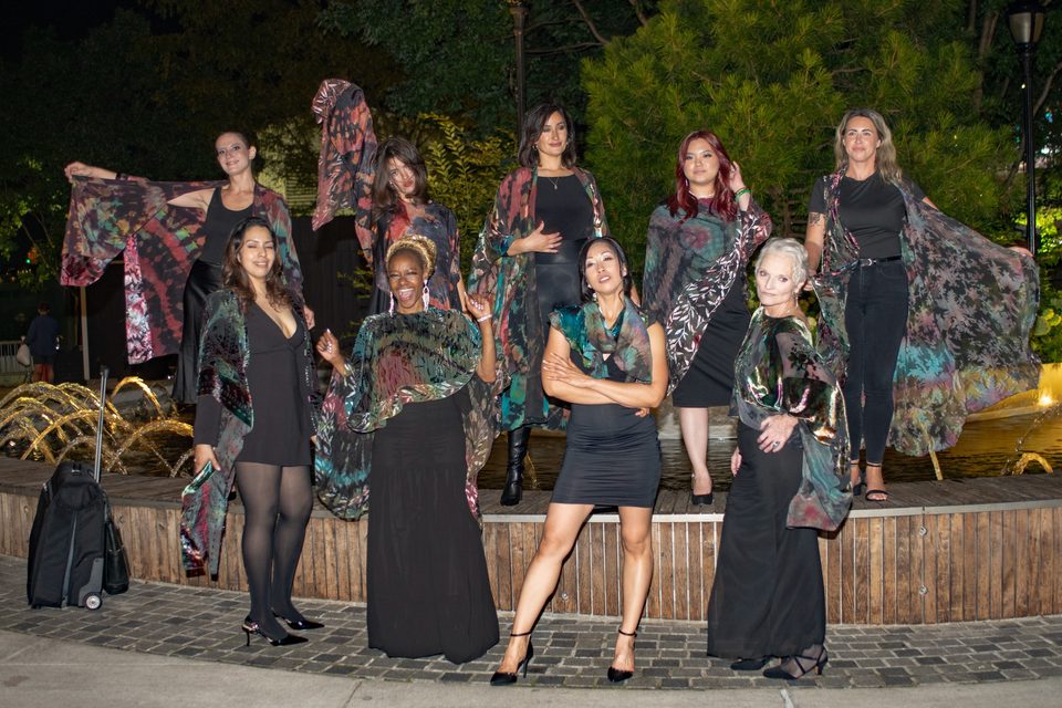 Group of models in Lorie Sadonia silk after the SB Fashion Global show, Bella Abzug Park at night. Gabriela is in the back row, left, holding a scarf open.